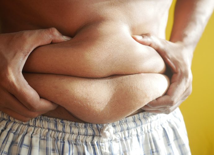 A Person Holding on to Belly Fat