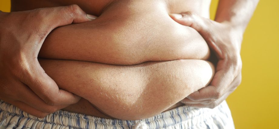 A Person Holding on to Belly Fat
